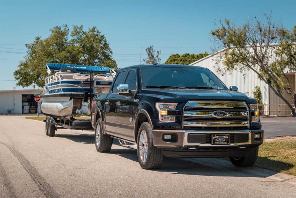 ford f250 towing a pontoon boat on a trailer