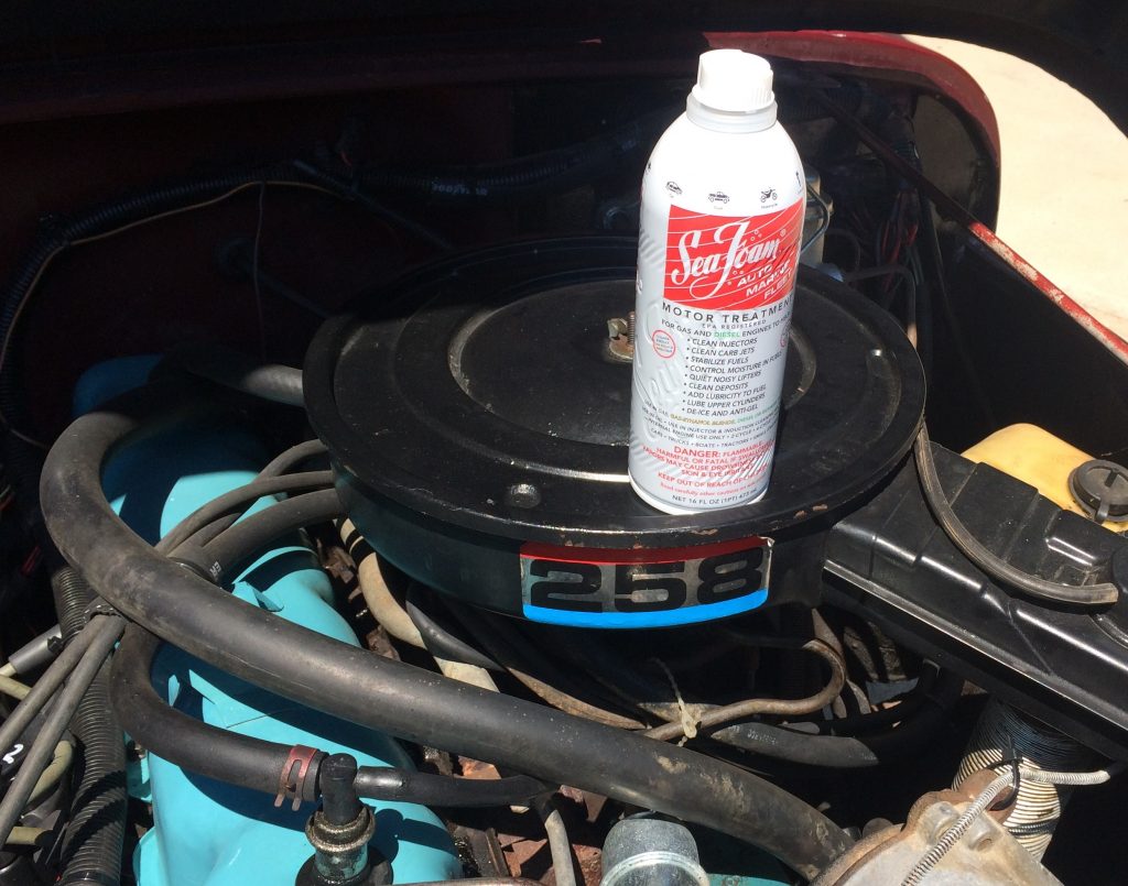 a can of seafoam engine treatment resting on the air cleaner of an amc 258 motor