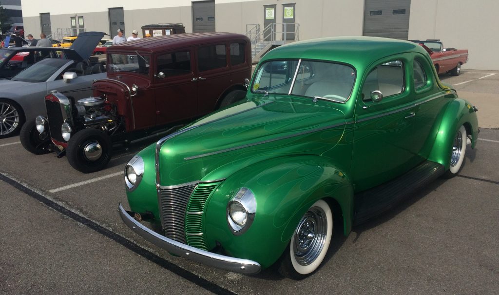 a pair of hotrods at a classic car show