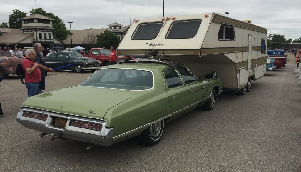 vintage chevy caprice pulling a roof mounted gooseneck shadow camper trailer