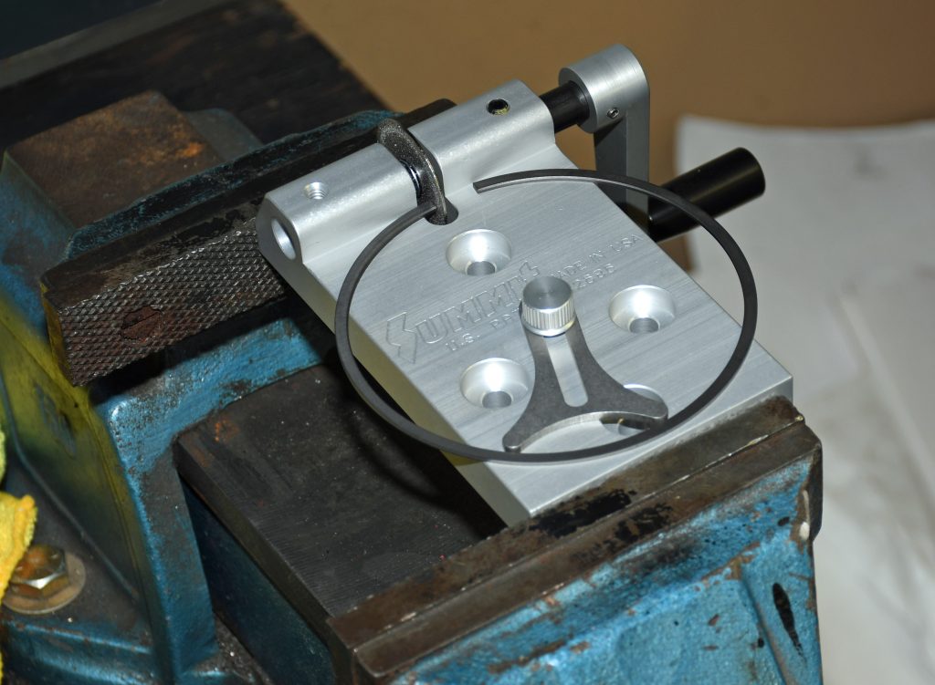 summit racing piston ring filing tool clamped in a bench vise prior to setting piston ring gap