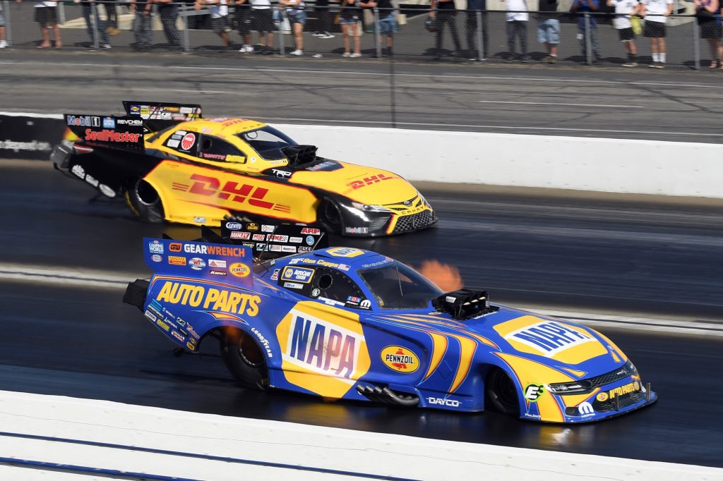 two funny cars race down the track during the 2021 NHRA winternationals