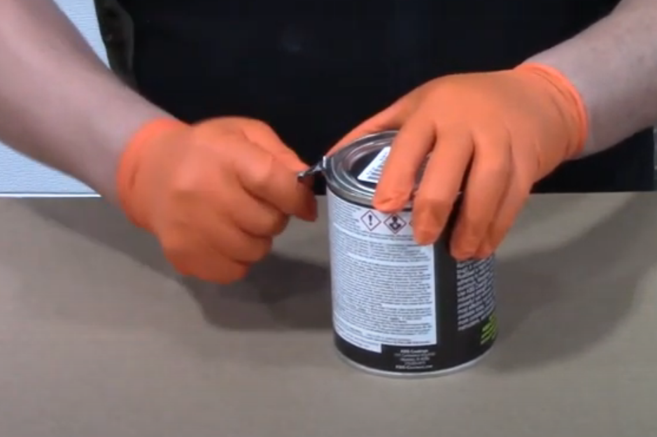 man opening a paint can lid