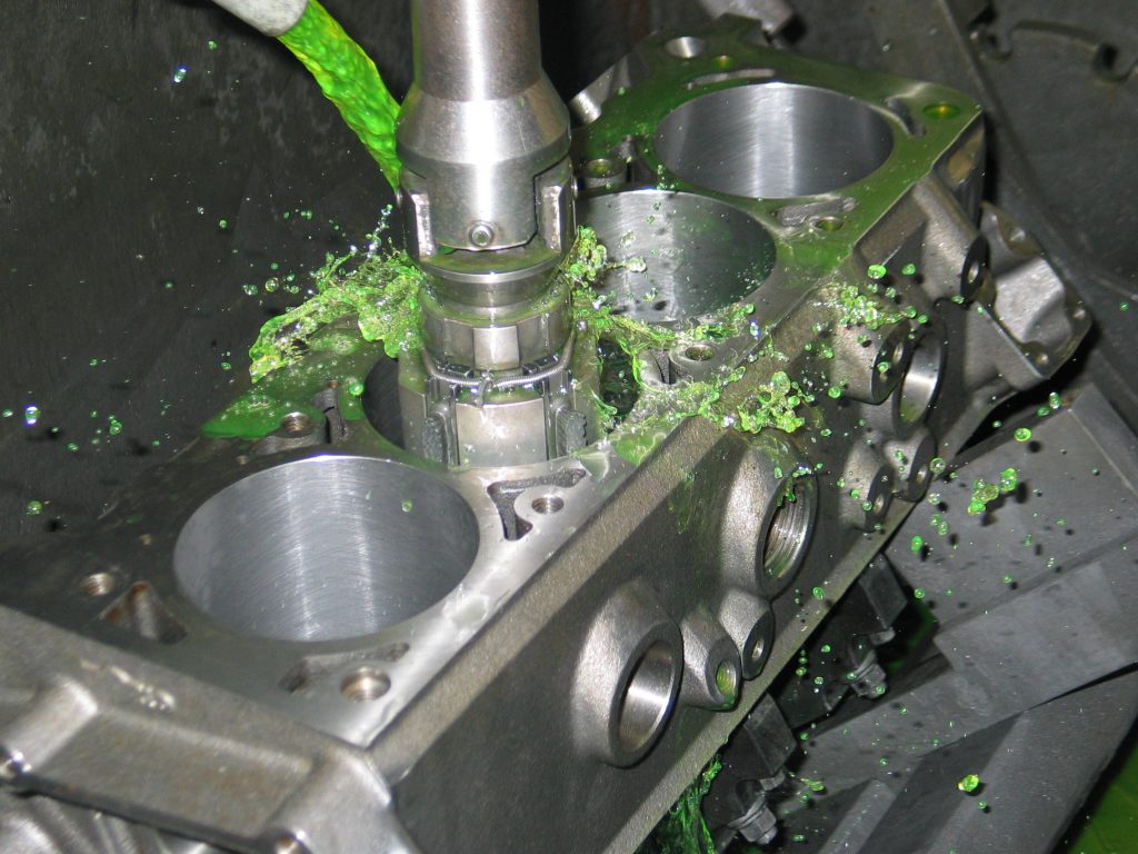 machine honing the cylinder bores of an engine with cutting lube