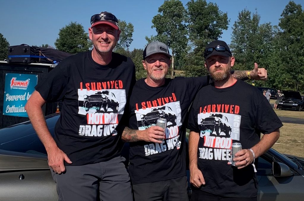 three men celebrating at a drag race