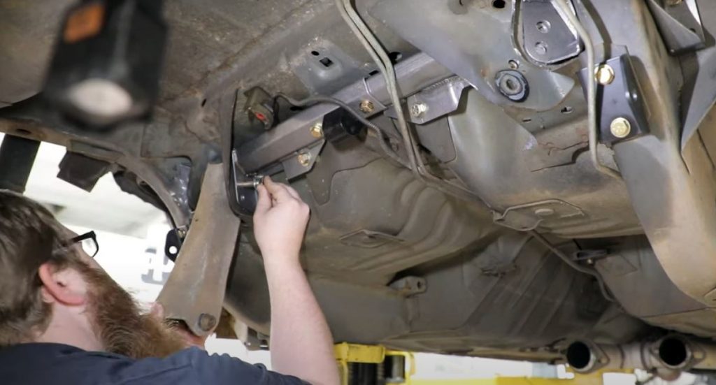 man installing detroit speed chassis stiffening kit on a ford mustang