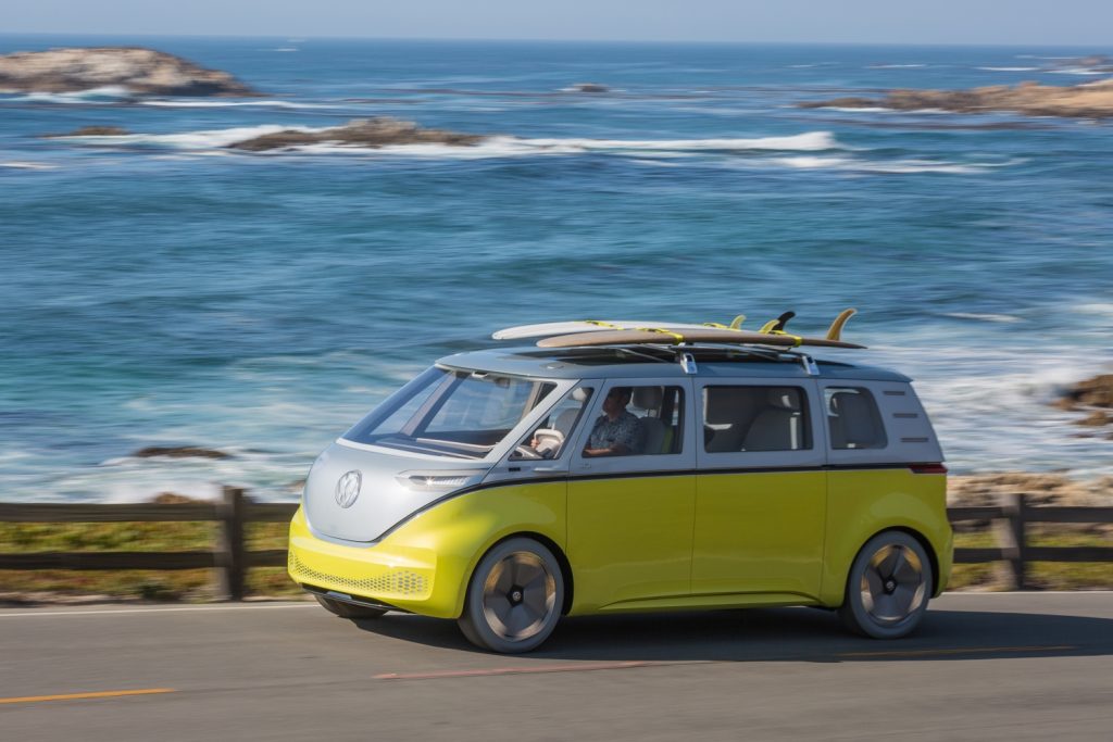 id.buzz ev concept van electric van with surfboards on rack near ocean
