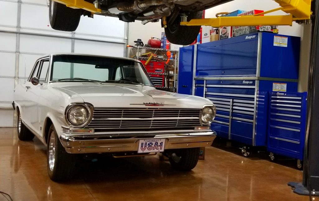 chevy nova 2 under two post lift in home garage