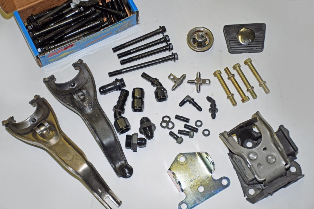 collection of vehicle parts and hardware scattered on a white table top