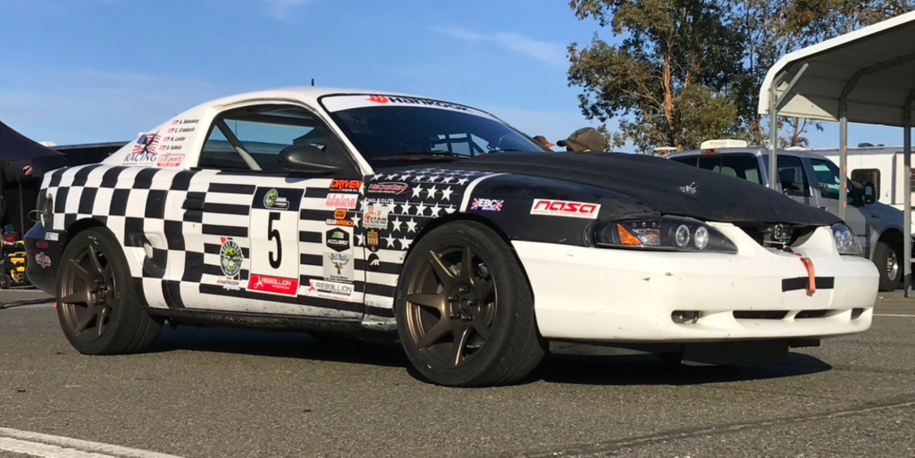 sn95 ford mustang race car in paddock