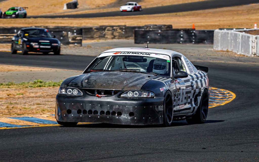 sn95 ford mustang race car on road course