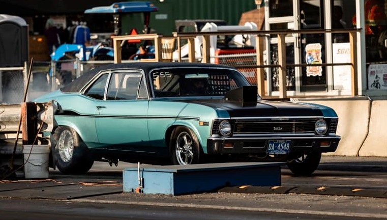 blue chevy nova ss does a burnout at a drag strip prior to launch