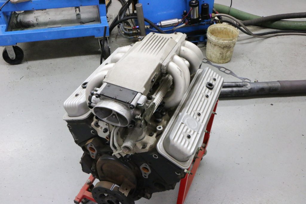chevy 305 tpi v8 small block engine on rolling engine stand in a shop