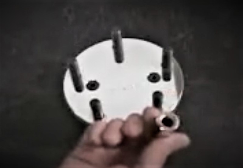 man holding up a nut in front of a wheel stud hub flange
