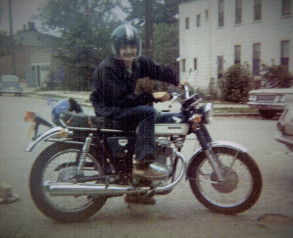 vintage photograph of man riding 1970 honda cb350 motorcycle