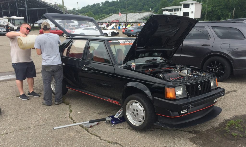 a dodge omni shelby glhs getting worked on between rounds during the summit racing midwest drags