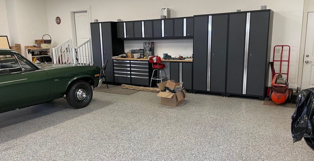 interior shot of a clean garage workspace with a green chevy nova parked nearby