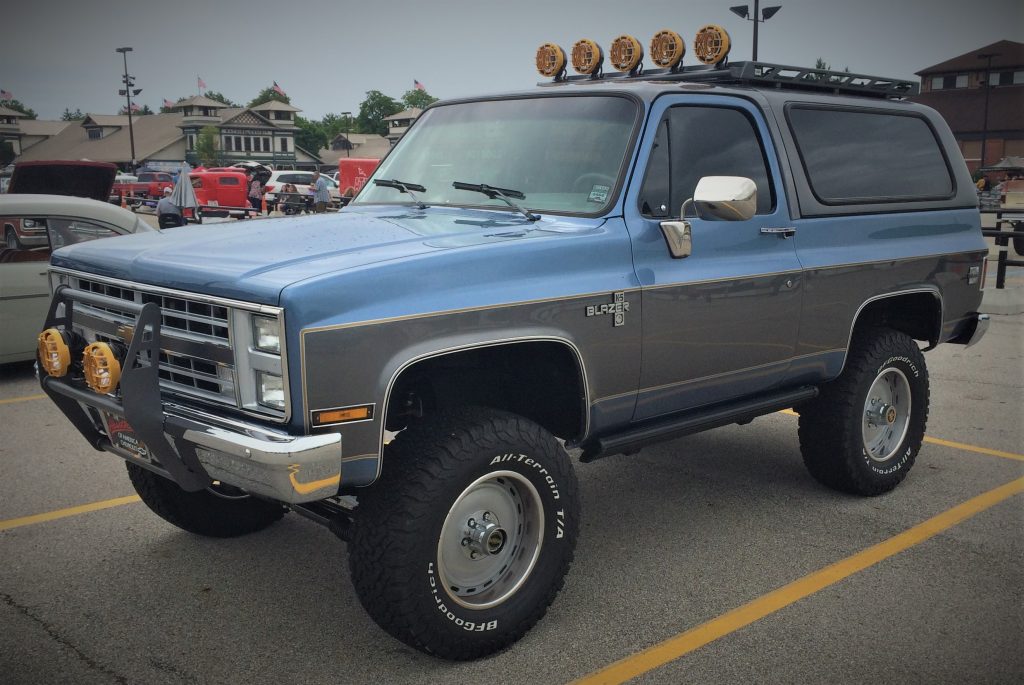 a blue and grey chevy blazer k5 at a classic car show