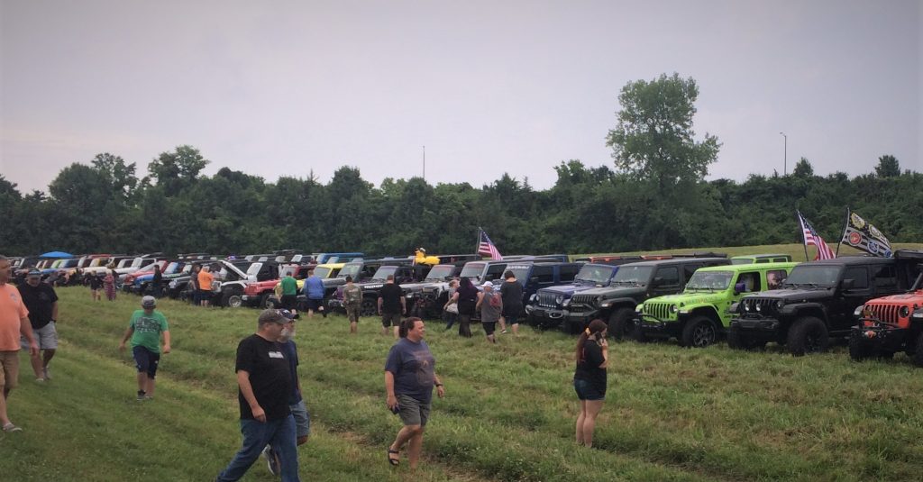 crowd of jeeps parked on the grass at a jeep show