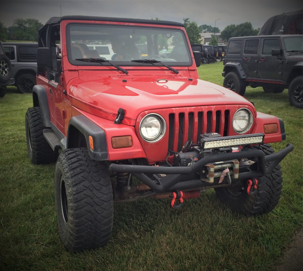 a red jeep wrangler tj with off road bumper and winch