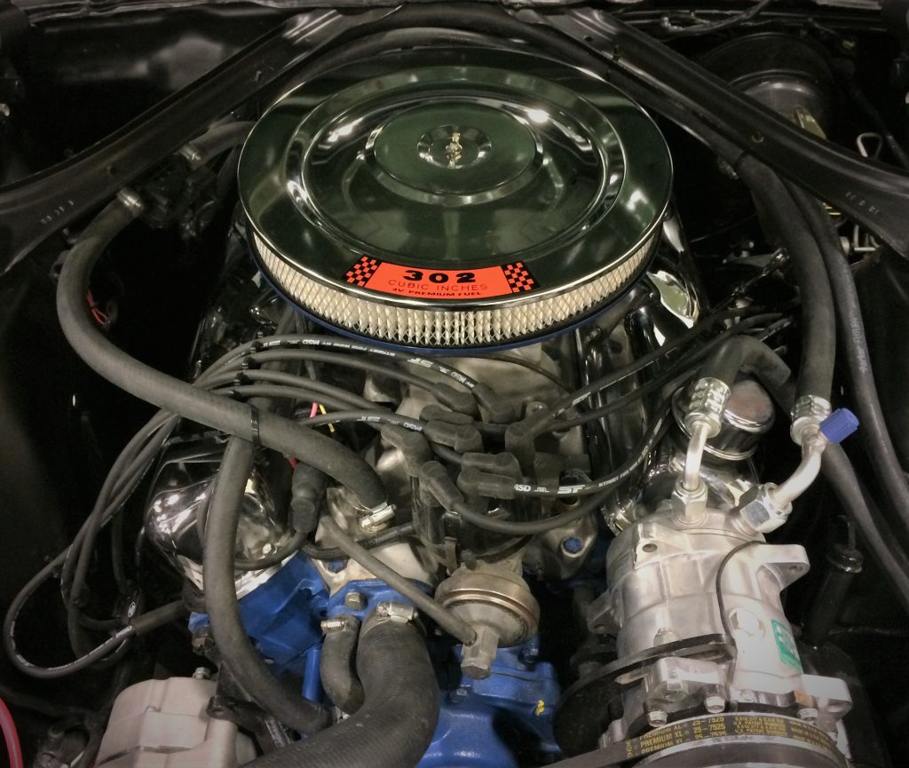 a ford 302 windsor v8 under the hood of a classic ford mustang