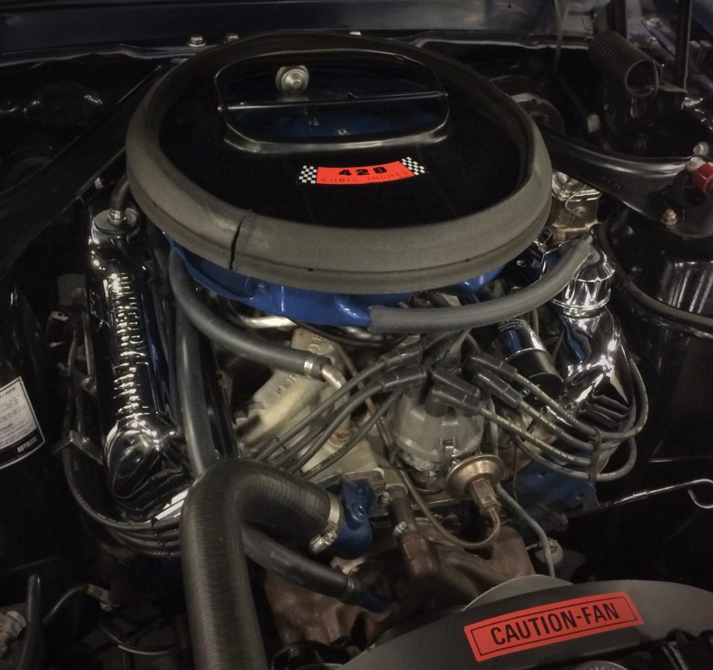 a ford 428 cubic inch v8 engine inside a vintage ford mustang