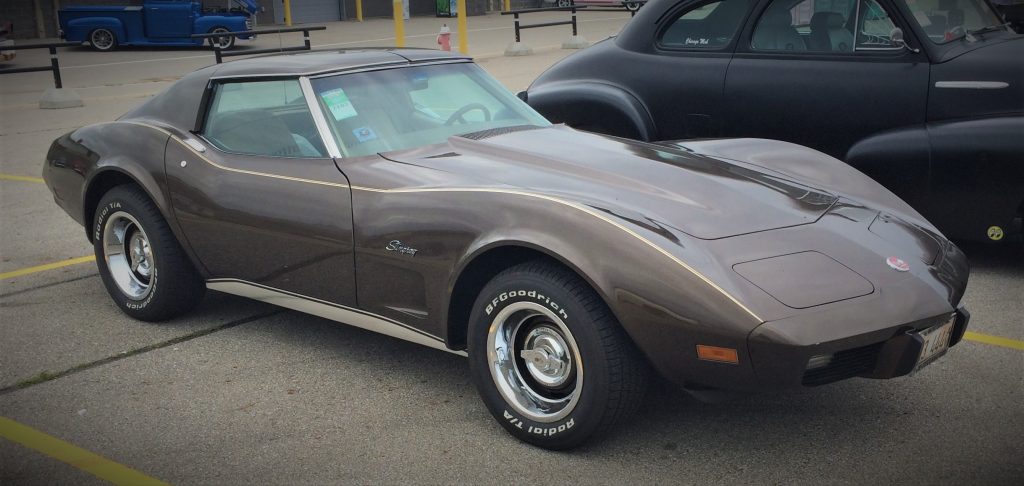 side view of a brown 1976 chevy corvette parked at a car show