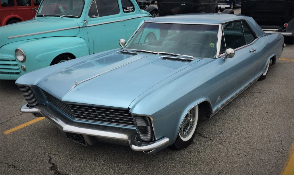 a lowered customized first-generation buick riviera at a classic car show