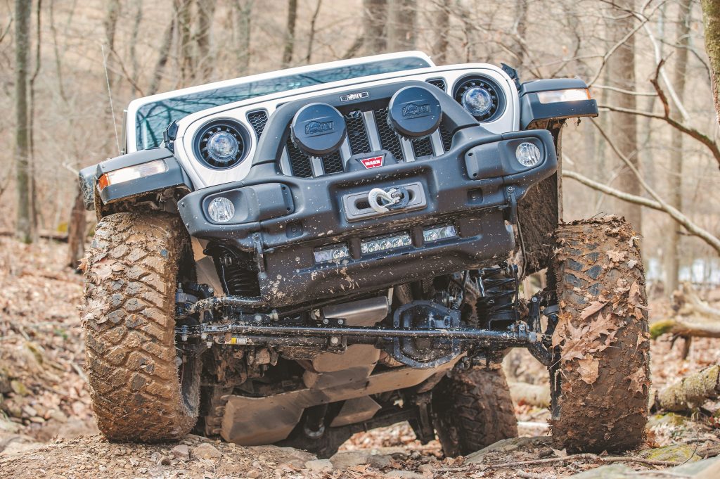 jeep wrangler front grille as it climbs dirt hill