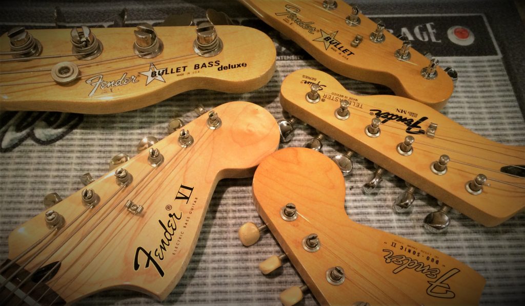 collection of fender electric guitar headstocks arranged in a circle