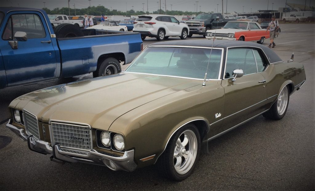 olive green cutlass hardtop coupe at a car show