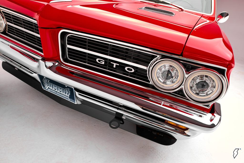 close up of gto emblem, tow hook, headlights & custom air dam chin spoiler on a 1964 pontiac