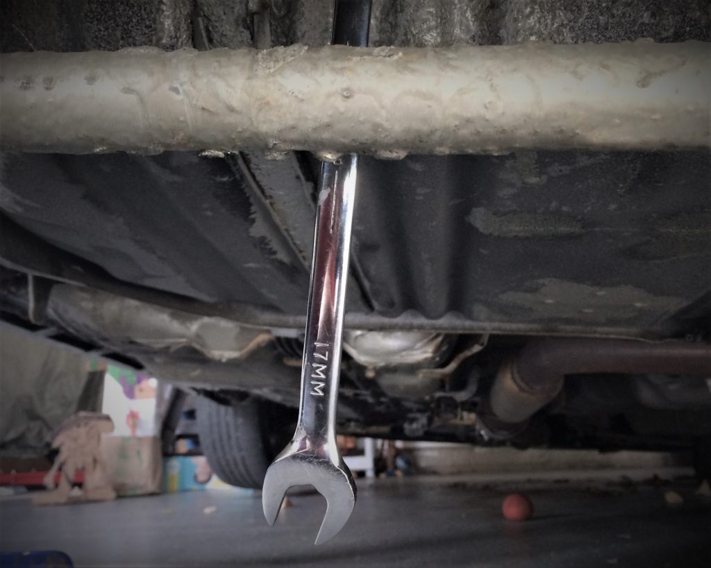 long handle 17 wrench dangling under a car