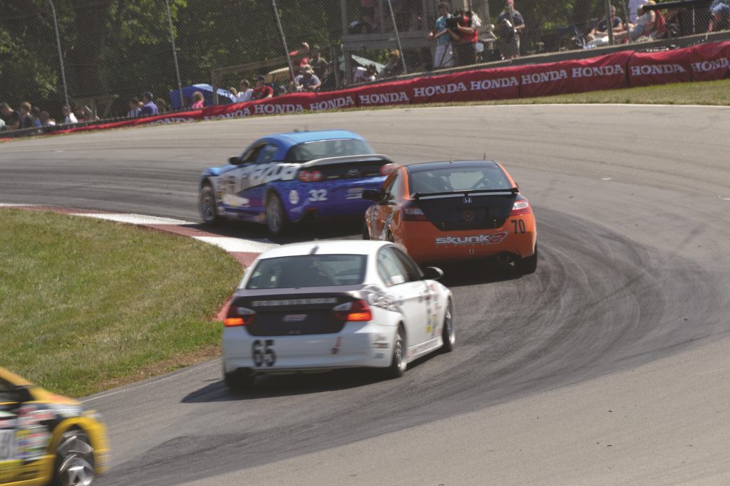 race cars taking a turn at mid ohio sports car course in lexington