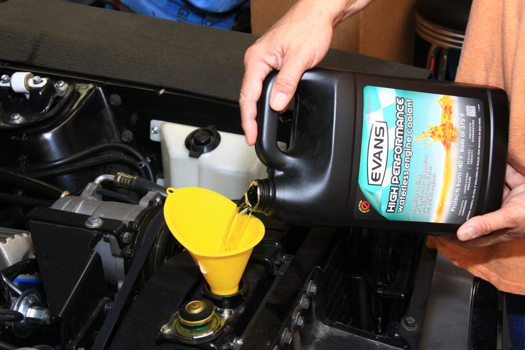pouring evans waterless coolant into an engine radiator