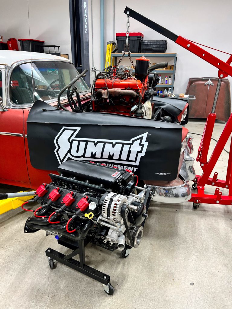 ls engine on stand in front of 1955 chevy hot rod project