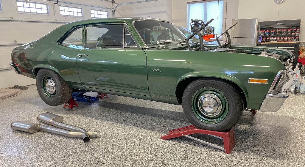 1970 green chevy nova car on jack stands in garage