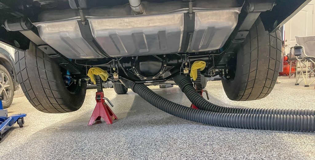garage exhuast system installed on tailpipes of an old muscle car