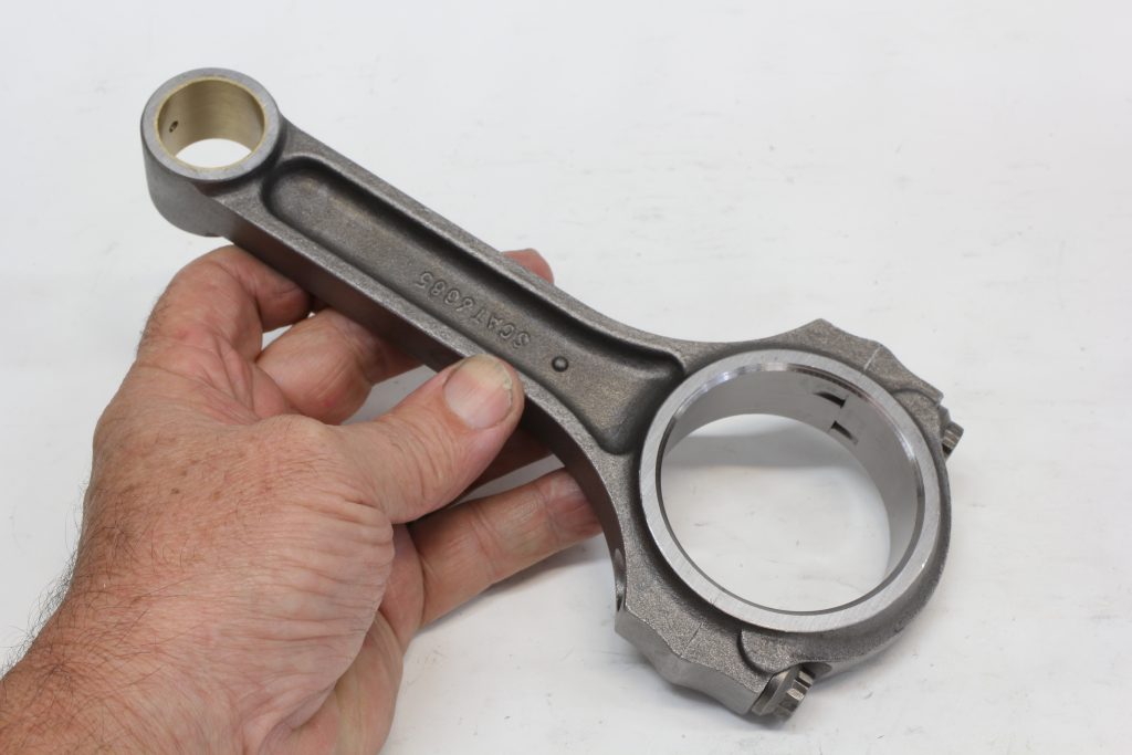 man holding an engine connecting rod