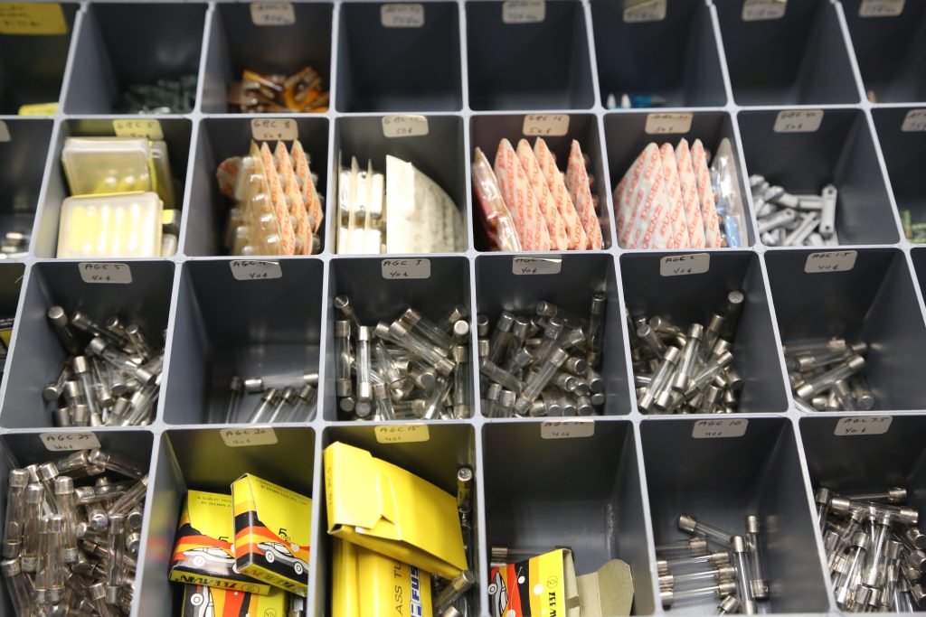 assortment of automotive electrical fuses in an organizer bin tray