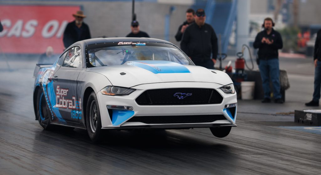 ford super cobra jet mustang 1800 launching at a drag strip with wheel stand