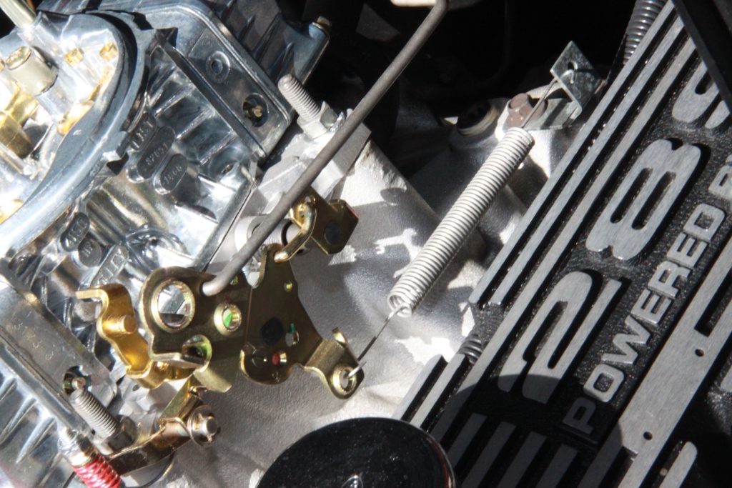 close up of throttle return spring on carburetor linkage