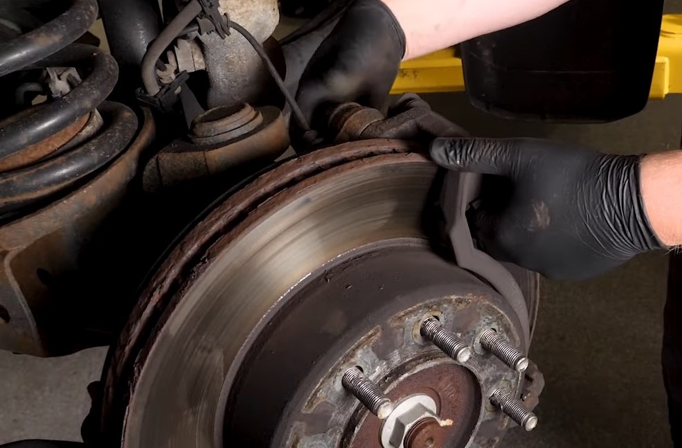man Removing a siezed brake rotor from a truck hub