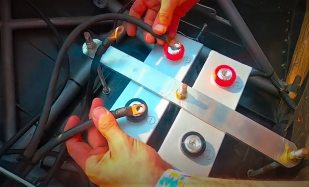 Man hooking up two batteries in a race car