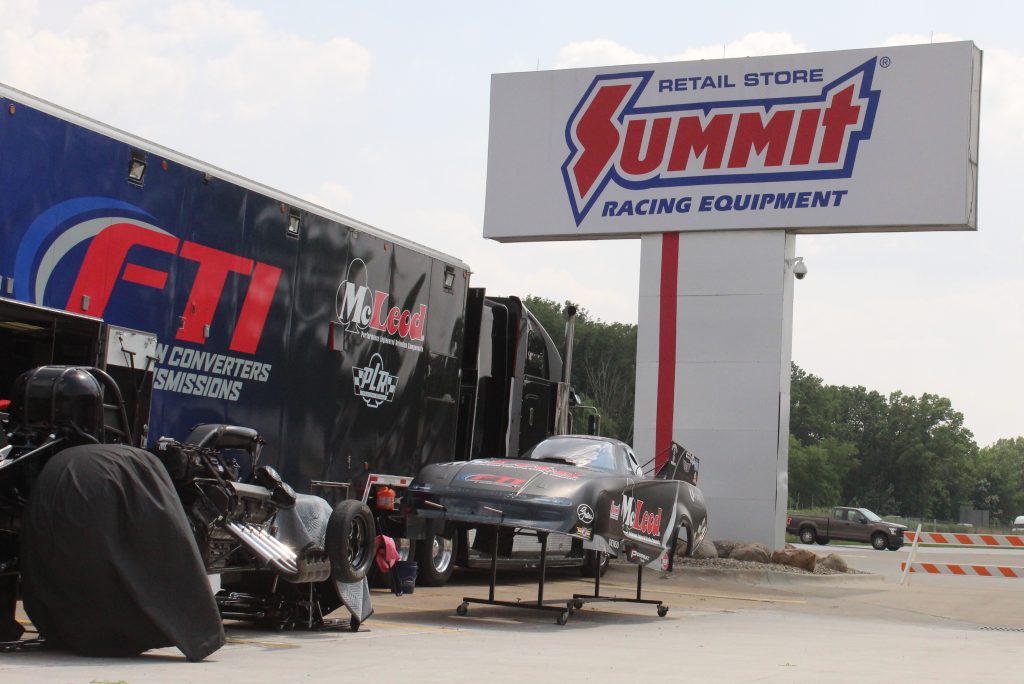 nhra funny car dragster and race trailer on display at summit racing