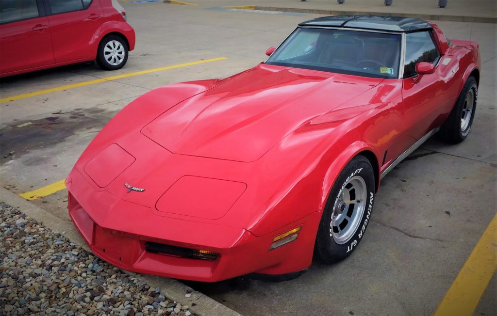 front driver side view of a red 1980 chevy corvette at summit racing store