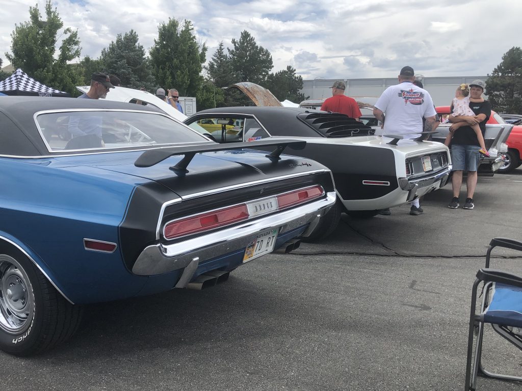 Rear view of a Dodge challenger and plymouth cuda at a car show