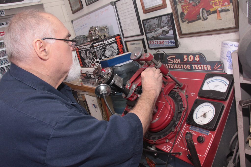 Man testing a vintage delco distributor on an old sun 504 tester machine