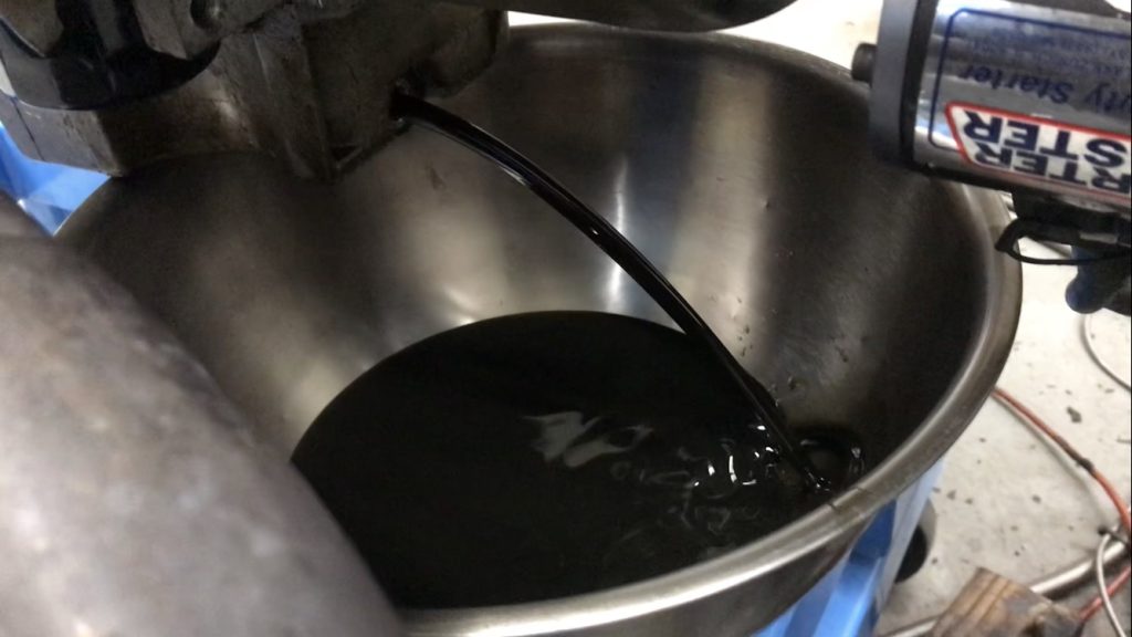 used engine oil pouring into drain pan