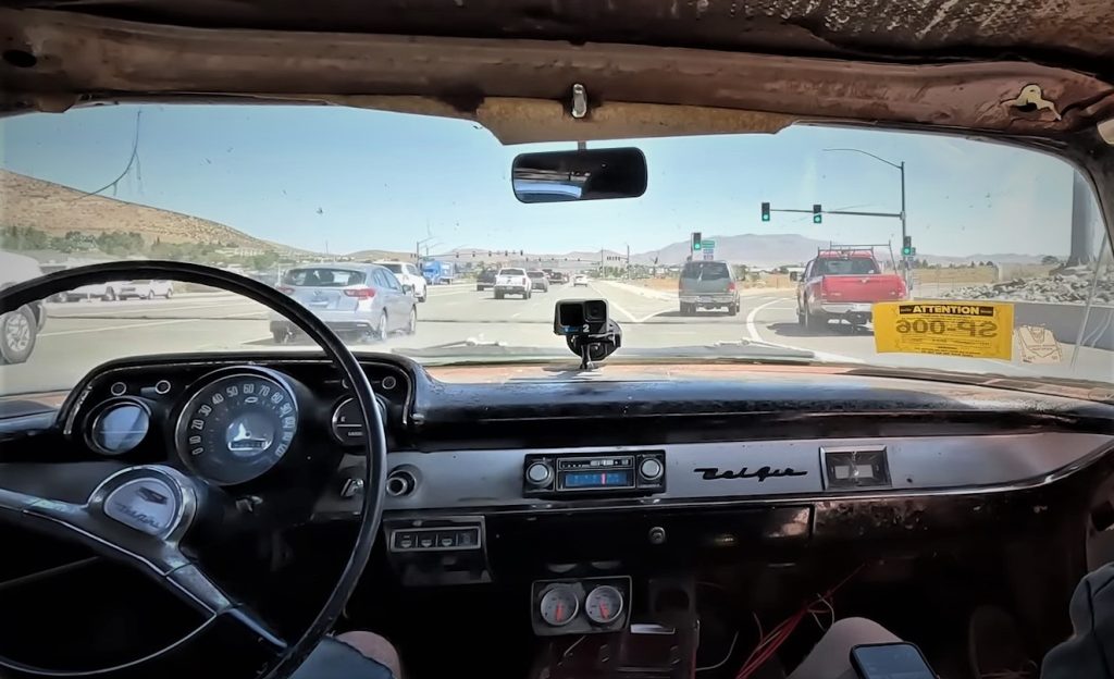 in seat view of driving a 1955 Chevy on highway